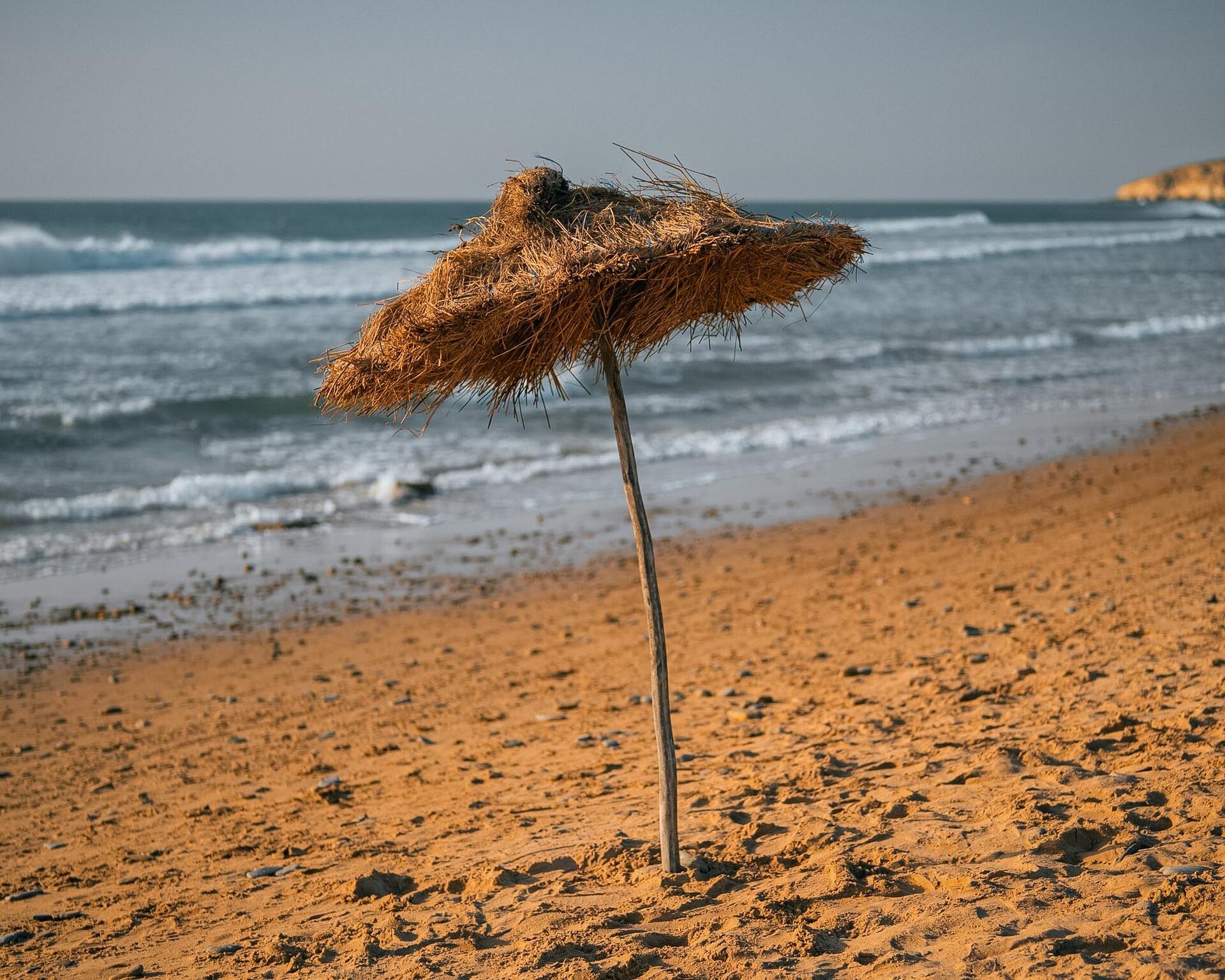 Parasol en feuilles de palmier face a l'ocean a Asilah